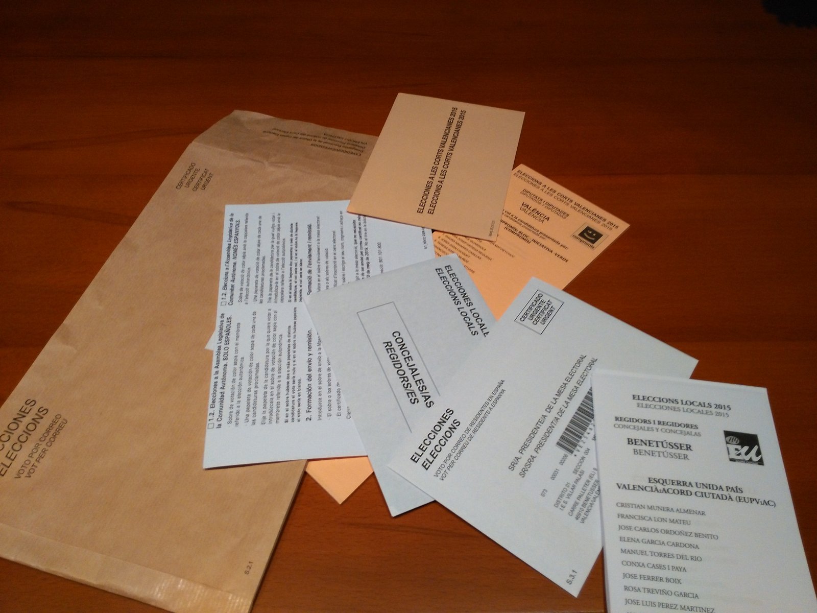 Papeletas, sobres y documentación del voto por correo español, extendidos sobre una mesa.